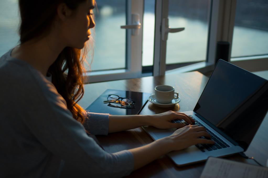 woman typing on her laptop at a desk